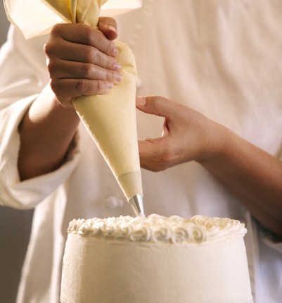 Close-up of a pastry chef decorating a cake